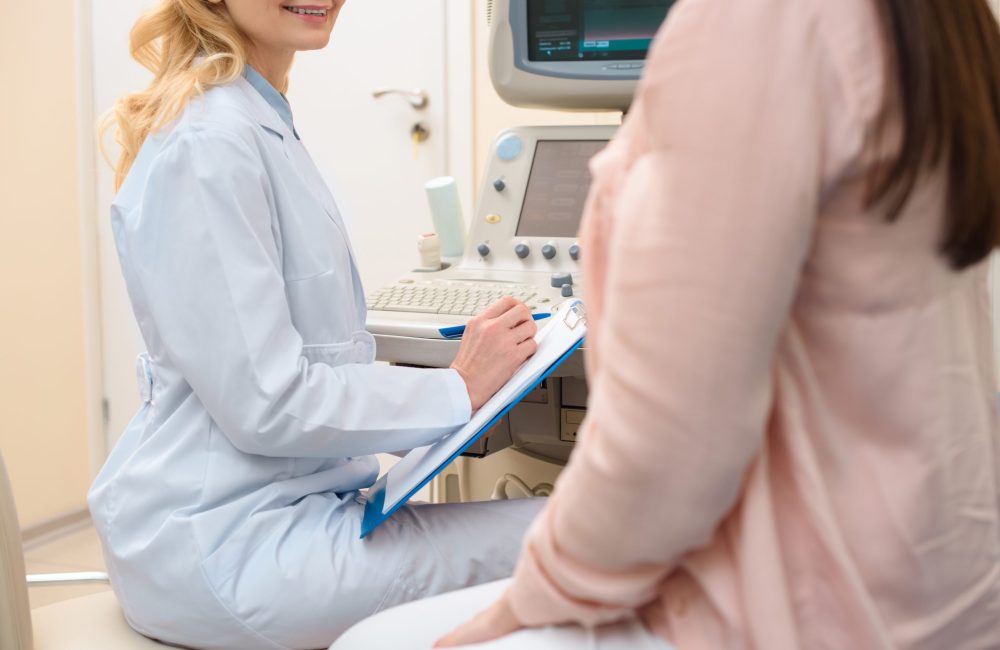 cropped shot of obstetrician gynecologist consulting pregnant woman at ultrasound scanning office